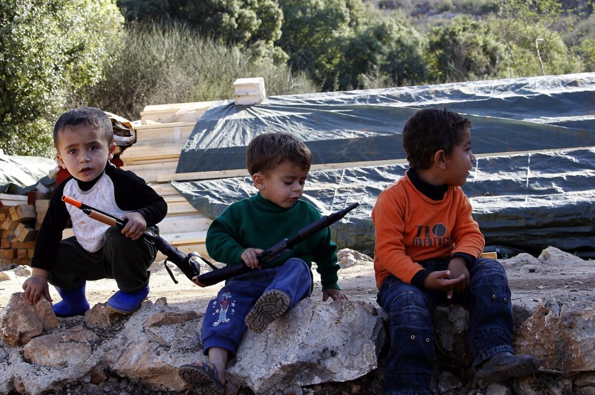 Syrian refugee children play with plastic weapons at a Syrian refugee camp in Ketermaya village, near Sidon, in southern Lebanon, on Tuesday. Peace prospects remain uncertain, despite a January date for peace talks in Geneva.