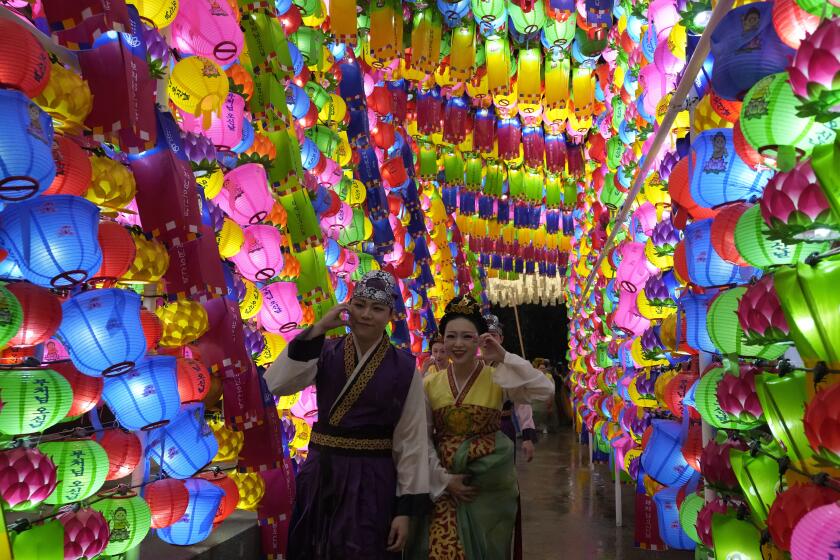 Una personas caminan junto a linternas durante el Festival de los Faroles de Loto, previo al cumpleaños de Buda en la Universidad Dongguk en Seúl, Corea del Sur, el sábado 11 de mayo de 2024. (Foto AP/Ahn Young-joon)