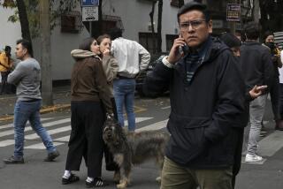 A man talks on a cell phone after an earthquake in Mexico City on December 7, 2023. A 5.8-magnitude earthquake shook much of central Mexico Thursday including the capital, prompting people to run out into the streets, the country's seismological institute said. (Photo by RODRIGO ARANGUA / AFP) (Photo by RODRIGO ARANGUA/AFP via Getty Images)
