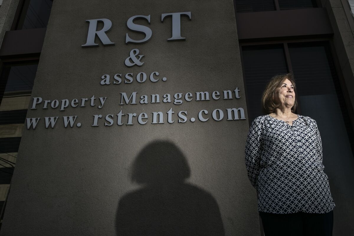 Irma Vargas stands in front of a sign for RST and Associates 