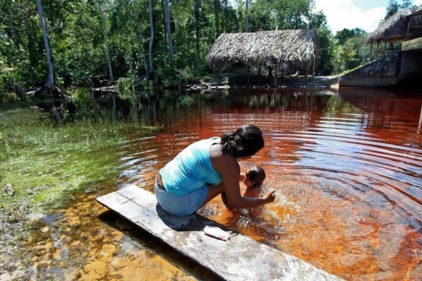 A woman bathes her daughter in Puerto Inirida, Colombia. U.S. Rep. Barbara Lee (D-Oakland) fears that climate change will bring about a rise in poverty that will push more women into the sex trade as an alternative to starvation.