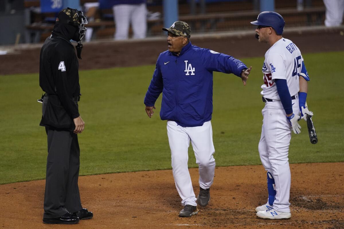 Dodgers manager Dave Roberts gets between umpire Chad Fairchild and Dodgers left fielder Matt Beaty.