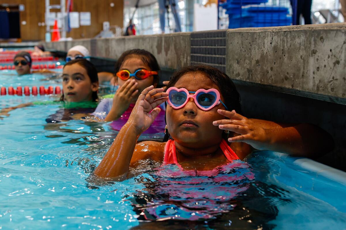 Children, some in swim goggles, in a pool 