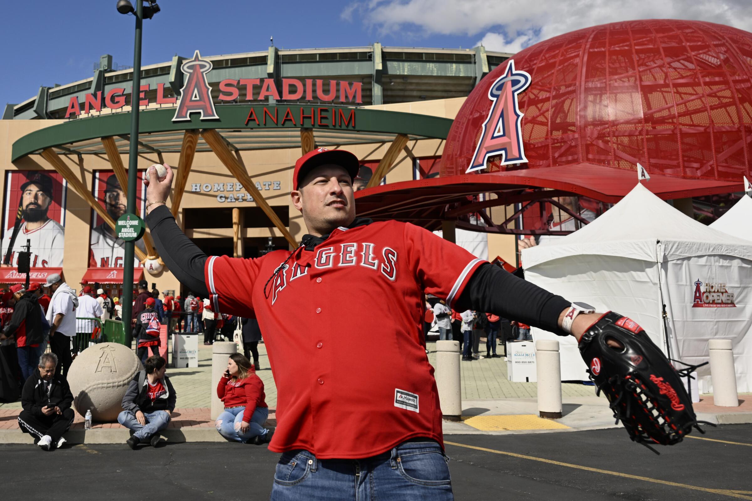 Angels fan Sam Sepanji throws a ball in front of Angel Stadium before the team's home opener 
