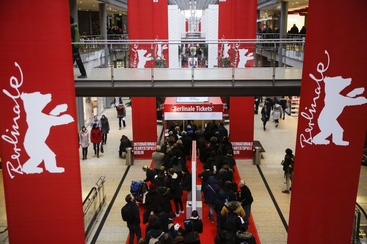 FILE - People line up in front of a ticket counter for tickets of the International Film Festival Berlinale inside a shopping mall at the Potsdamer Platz square in Berlin, Feb. 12, 2018. The Berlin International Film Festival will take place next month despite rising virus numbers in Germany, especially in the German capital. The festival management said Wednesday Jan. 12, 2022, only people who have already been vaccinated against the coronavirus or have recently recovered from an infection will have access. (AP Photo/Markus Schreiber, File)
