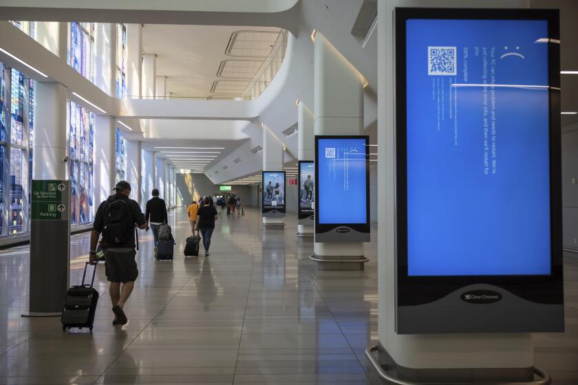 Screens show a blue error message at a departure floor of LaGuardia Airport in New York on Friday, July 19, 2024, after a faulty CrowdStrike update caused a major internet outage for computers running Microsoft Windows. (AP Photo/Yuki Iwamura)