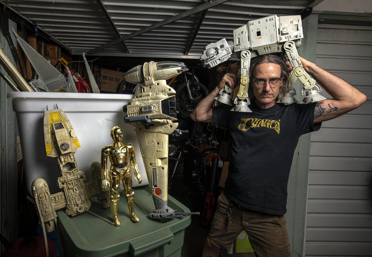 A man poses with his Star Wars toys