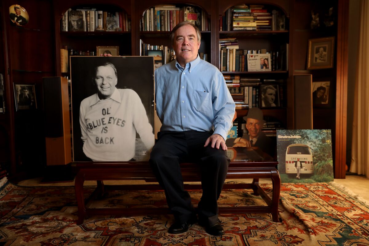 Jim Mahoney, owner of the largest collection of Frank Sinatra  memorabilia in the country, with an enlarged photo of Sinatra.
