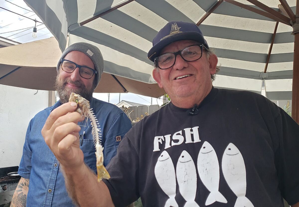 Tommy Gomes of "The Fishmonger" TV series greets sustainable-seafood advocate and chef Rob Ruiz (left).