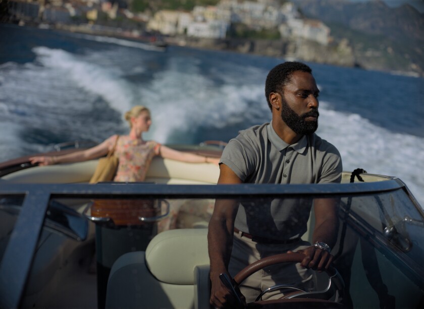 This image released by Warner Bros. Entertainment shows Elizabeth Debicki, left, and John David Washington in a scene from "Tenet." Warner Bros. says it is delaying the release of Christopher Nolan's sci-fi thriller “Tenet” until Aug. 12. (Melinda Sue Gordon/Warner Bros. Entertainment via AP)