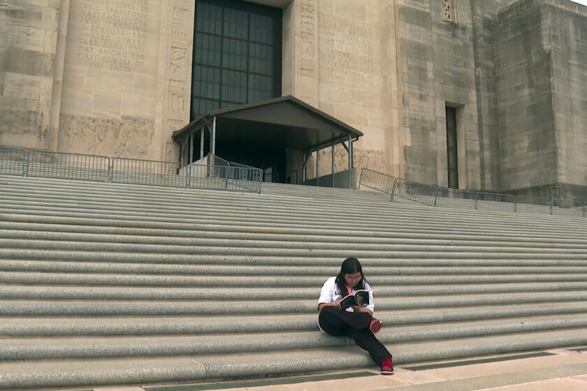 Arielle Leighton, 13, reads on the Louisiana Capitol steps in Baton Rouge, La., on Tuesday, April 16, 2024. The eighth grader, who is a transgender girl, visited the state building with her Dad to oppose bills targeting the state’s LGBTQ+ community. (AP Photo/Stephen Smith)