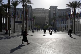 FILE - People walk through the venue at the COP28 U.N. Climate Summit near the Al Wasl Dome at Expo City, Thursday, Nov. 30, 2023, in Dubai, United Arab Emirates. (AP Photo/Rafiq Maqbool, File)