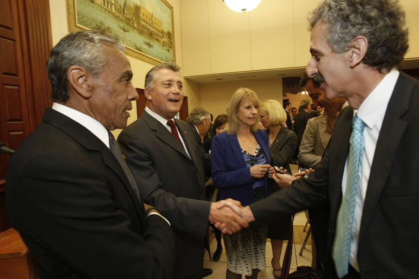 Incumbent Los Angeles City Atty. Carmen Trutanich, second from left, shakes hands with his challenger, Mike Feuer, at a debate last month.