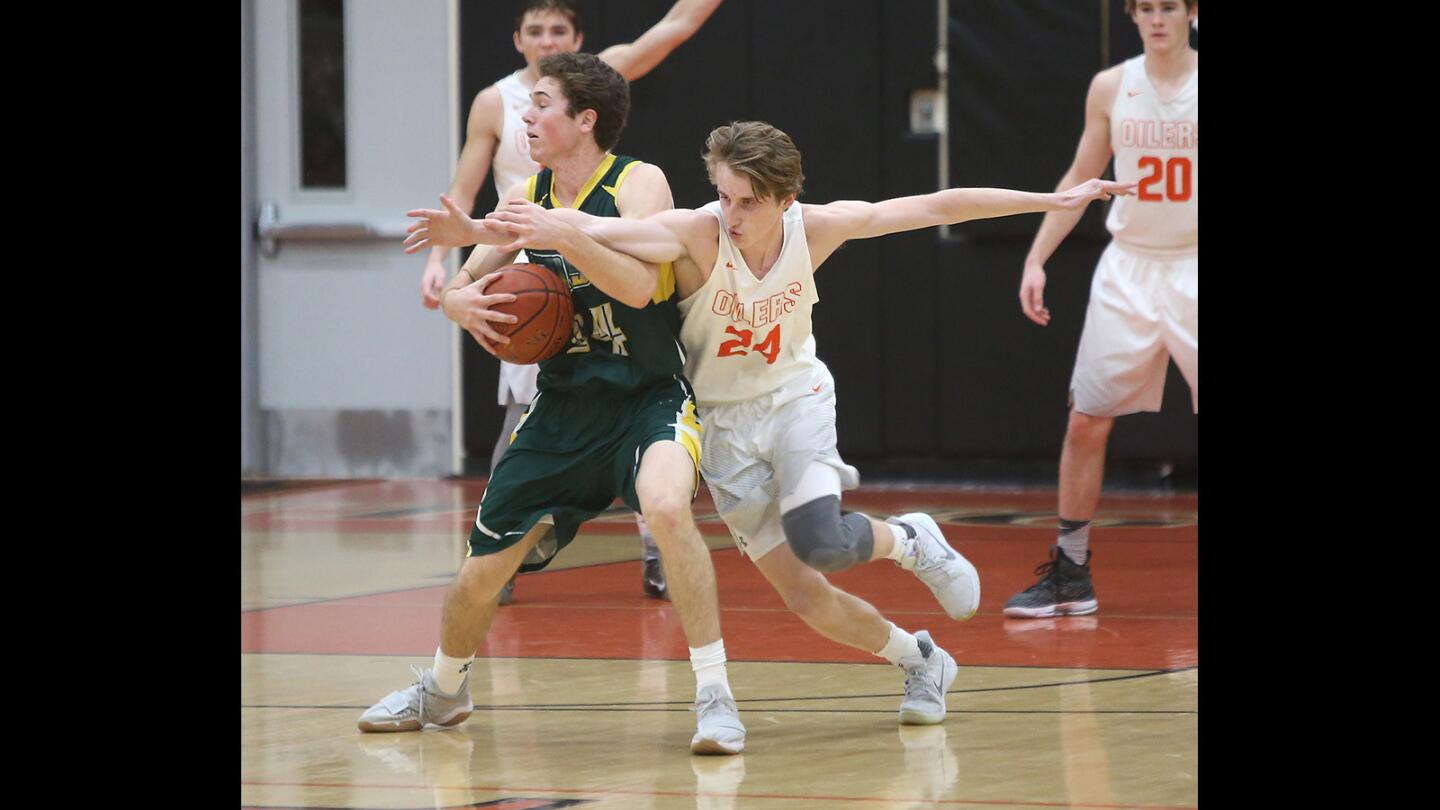 Huntington's Cade Ortiz tries to steal at the top of the key from Edison's Spencer Serven in boys varsity basketball action on Thursday.