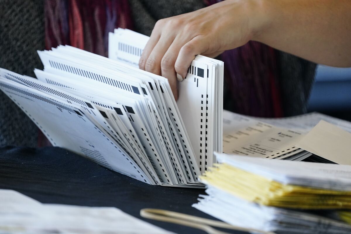 An election worker handles ballots Nov. 5 at the State Farm Arena in Atlanta.