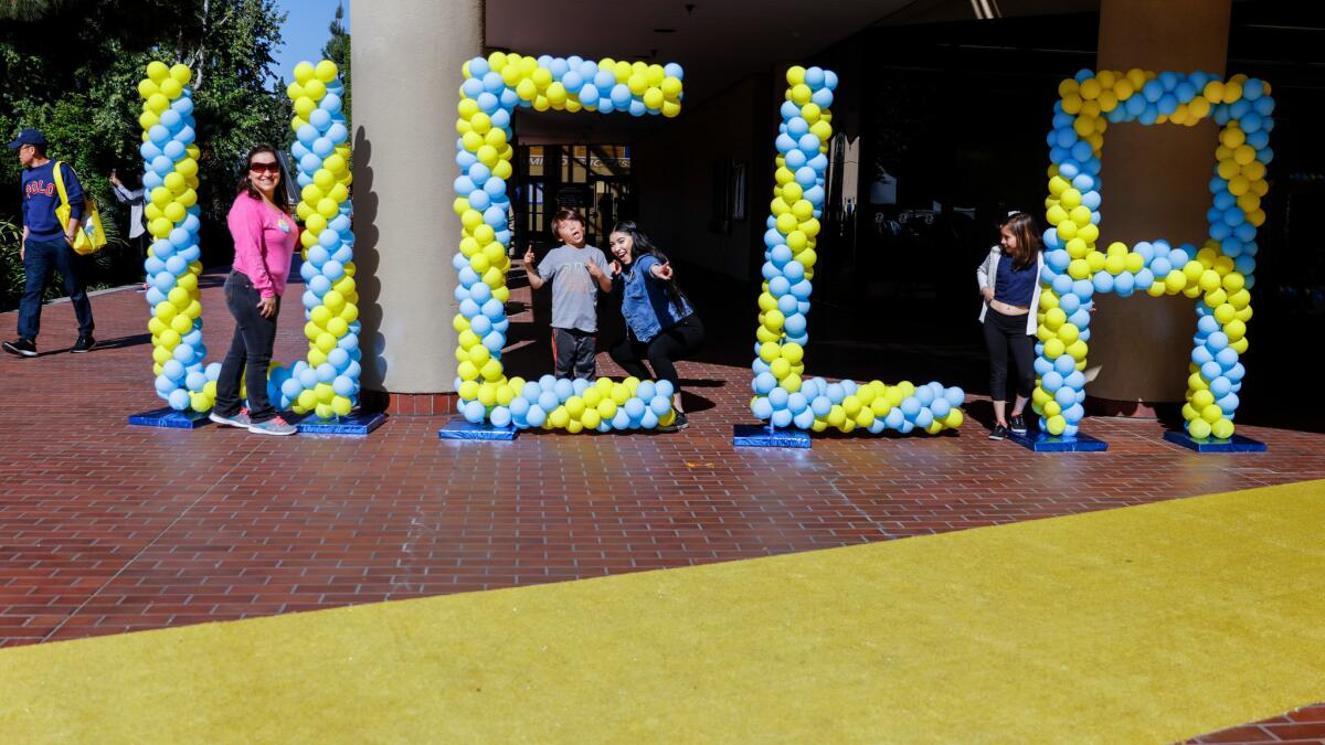 Janet Mejia, left, from Sun Valley and her kids Emmanuel, Jennifer and Samantha, from left, pose for pictures with balloons spelling UCLA, during the annual Bruins Day.