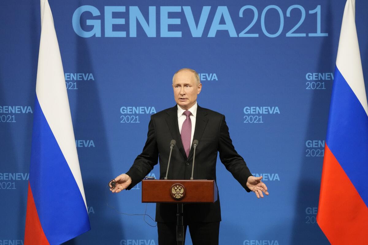 Russian President Vladimir Putin speaks at a lectern before a blue backdrop that says 'Geneva 2021'