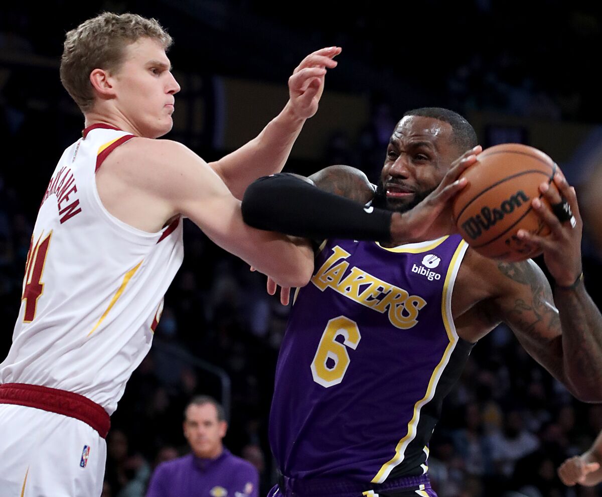 Lakers forward LeBron James drives to the basket in front of Cleveland Cavaliers forward Lauri Markkanen.
