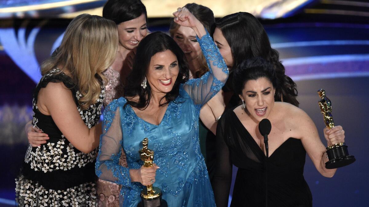 Melissa Berton and Rayka Zehtabchi accept the award for best documentary short subject for "Period. End of Sentence" at the Oscars in Los Angeles on Sunday.