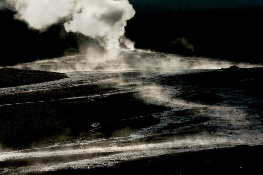 Steam rises from the base of the Old Faithful geyser in Yellowstone National Park.