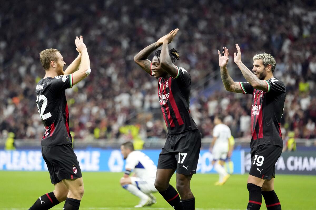 AC Milan's Tommaso Pobega, left, celebrates with teammate Rafael Leao, center, and Theo Hernandez after scoring his side's third goal during the Champions League, Group E soccer match between AC Milan and Dinamo Zagreb, at the San Siro stadium in Milan, Italy, Wednesday, Sept. 14, 2022. (AP Photo/Luca Bruno)