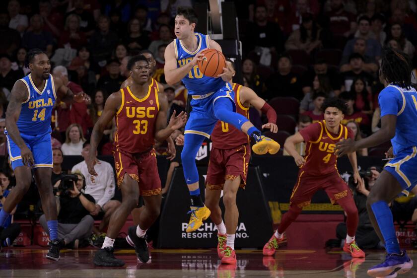 LOS ANGELES, CALIFORNIA - JANUARY 27: Lazar Stefanovic #10 of the UCLA Bruins grabs a rebound in front of Kijani Wright #33 and Kobe Johnson #0 of the USC Trojans in the first half at Galen Center on January 27, 2024 in Los Angeles, California. (Photo by Jayne Kamin-Oncea/Getty Images)