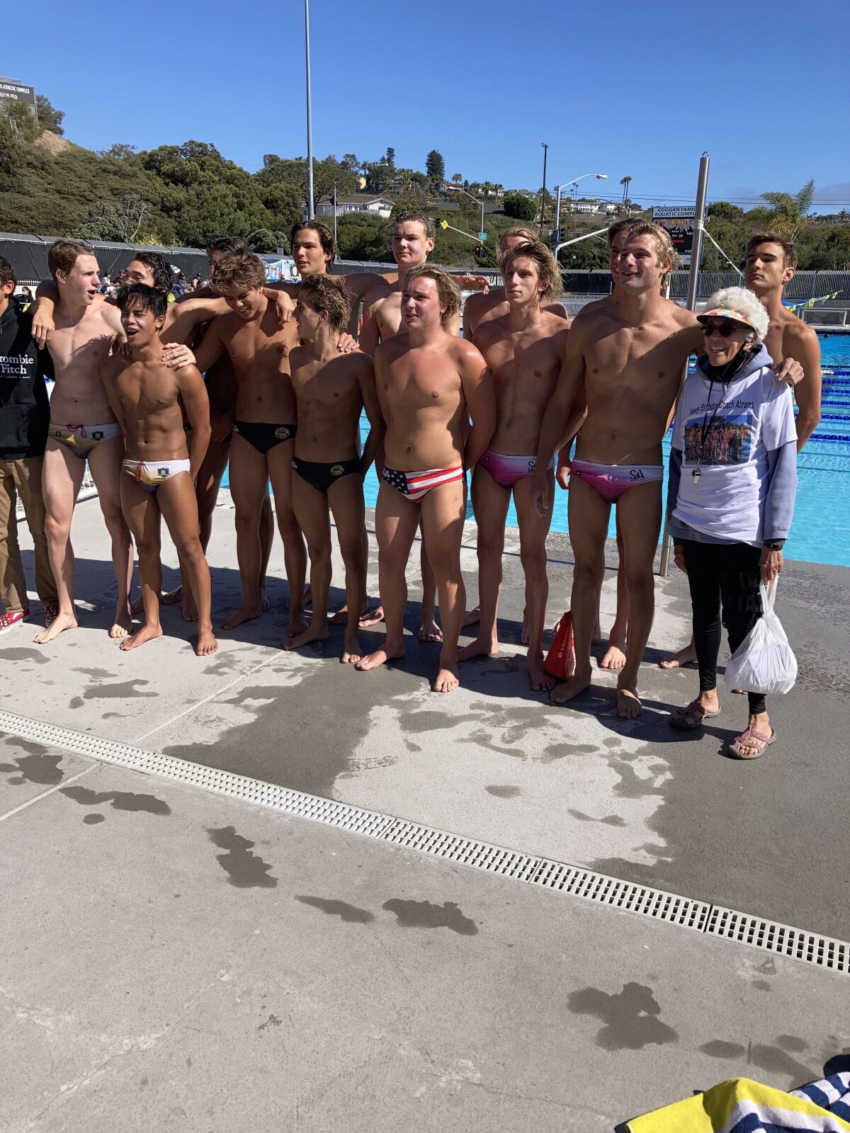 Joyce Abrams stands with the La Jolla High School 2020-21 boys water polo team, which named her its honorary coach.