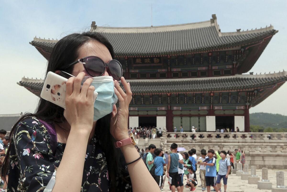 A Chinese tourist wears a mask as a precaution against the Middle East Respiratory Syndrome virus during a visit to Gyeongbok Palace in Seoul on June 1.
