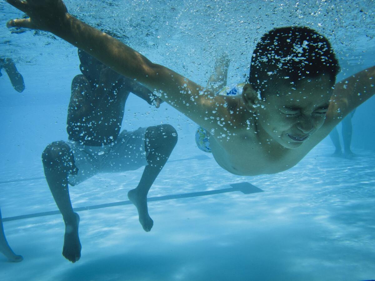 Children keep cool by swimming in a pool at a Westchester recreation center.