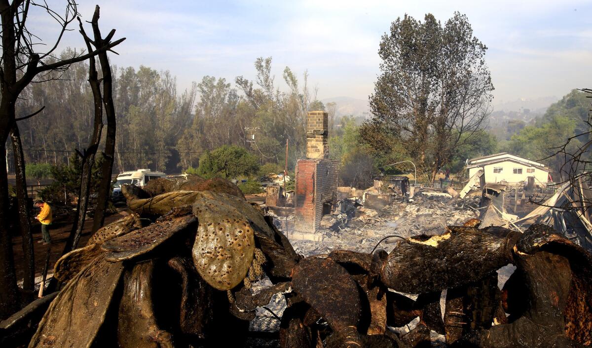 A home smolders on Mount Whitney Road in Escondido as the Cocos fire continues to burn.