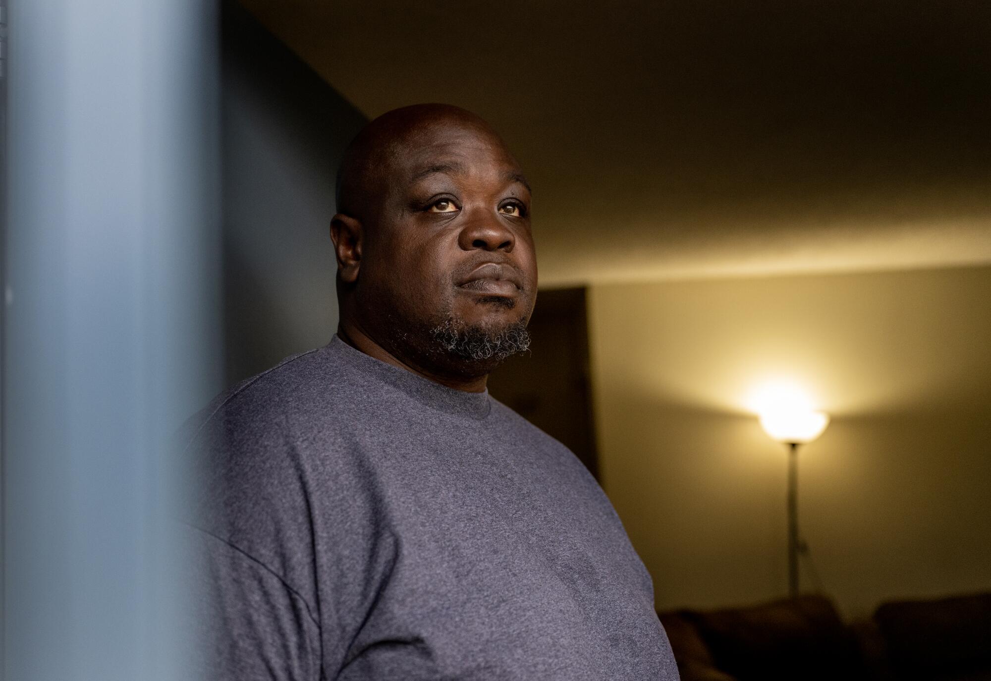 A man looks out from an apartment.