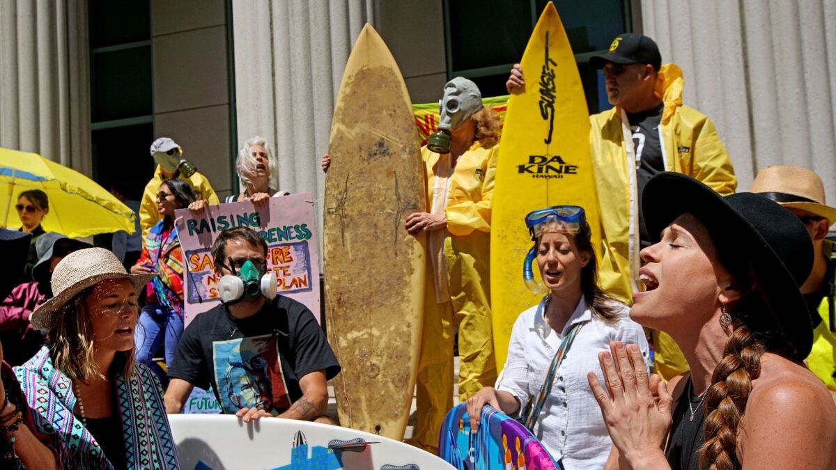 Protesters, some wearing wearing hazmat suits, stand outside San Diego Superior Courthouse to rally against nuclear waste disposal from the San Onofre Power Plant in San Diego, California, April 14, 2017.