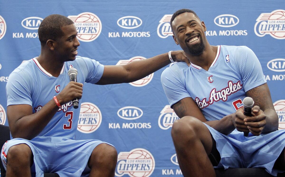 Clippers point guard Chris Paul, left, shares a light-hearted moment with center DeAndre Jordan during Clippers media day on Monday. Jordan was all business at training camp Tuesday.
