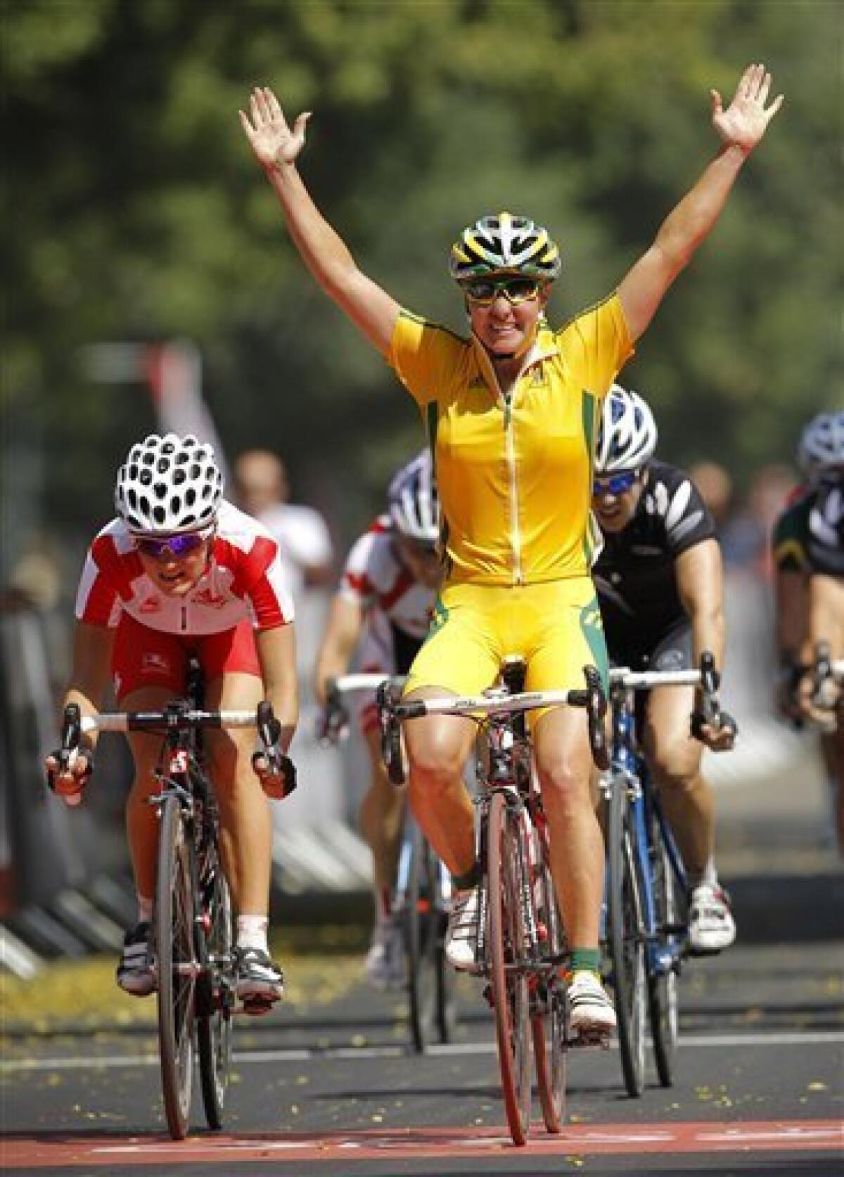 Australia's Rochelle Gilmore, right, celebrates as she crosses the finish line, followed by England's Elizabeth Armitstead, left, to win the women's 112km cycling road race during the Commonwealth Games in New Delhi, India, Sunday, Oct. 10, 2010. (AP Photo/Victor R. Caivano)