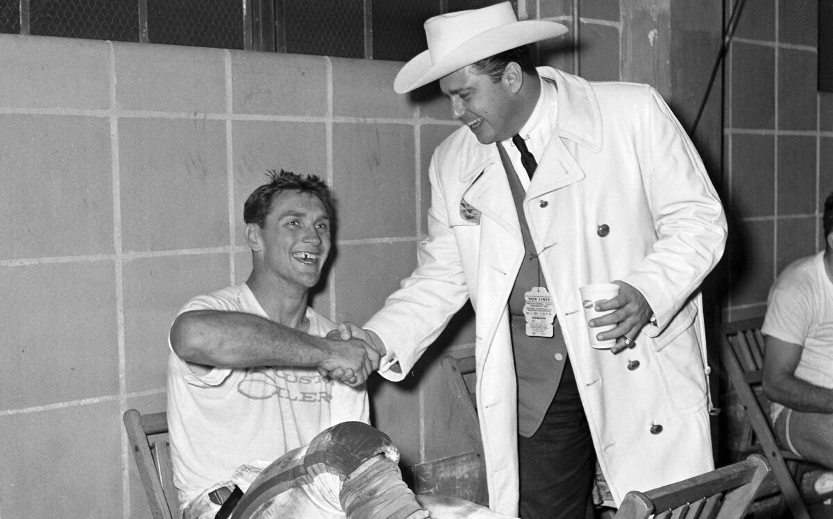 In this 1960 photo, Kenneth Stanley "Bud" Adams, right, shakes hands with the Houston Oilers' Billy Cannon in the dressing room in Houston. Adams died of natural causes in his Houston home, the Tennessee Titans announced Monday. He was 90.