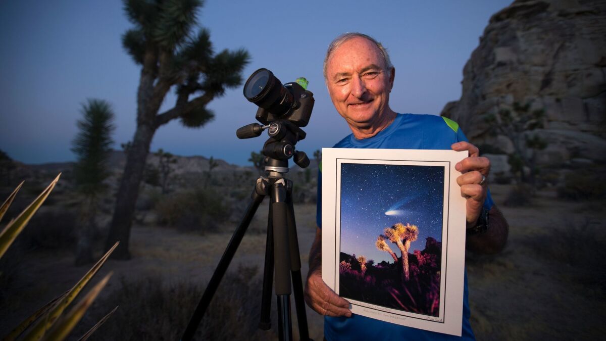 Wally Pacholka, a renowned landscape photographer who has been photographing the night sky over Joshua Tree National Park for 50 years, holds a print of a photo he took at the park of comet Hale-Bopp on March 31, 1997.