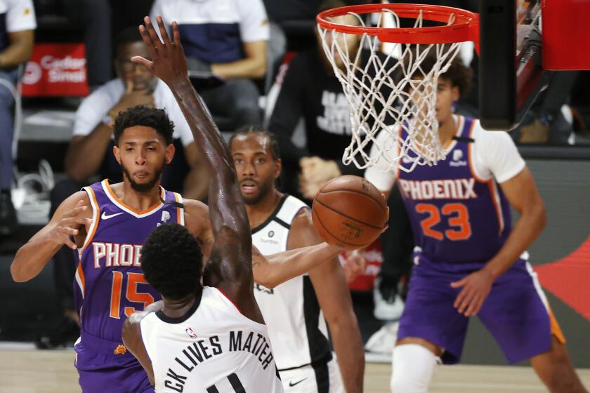 Phoenix Suns' Cameron Payne (15) looks to pass around Los Angeles Clippers' JaMychal Green.