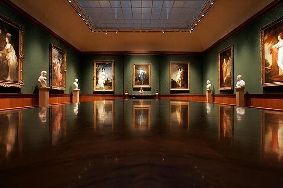 A wide view of the Thornton Portrait Gallery at the Huntington, lined with paintings