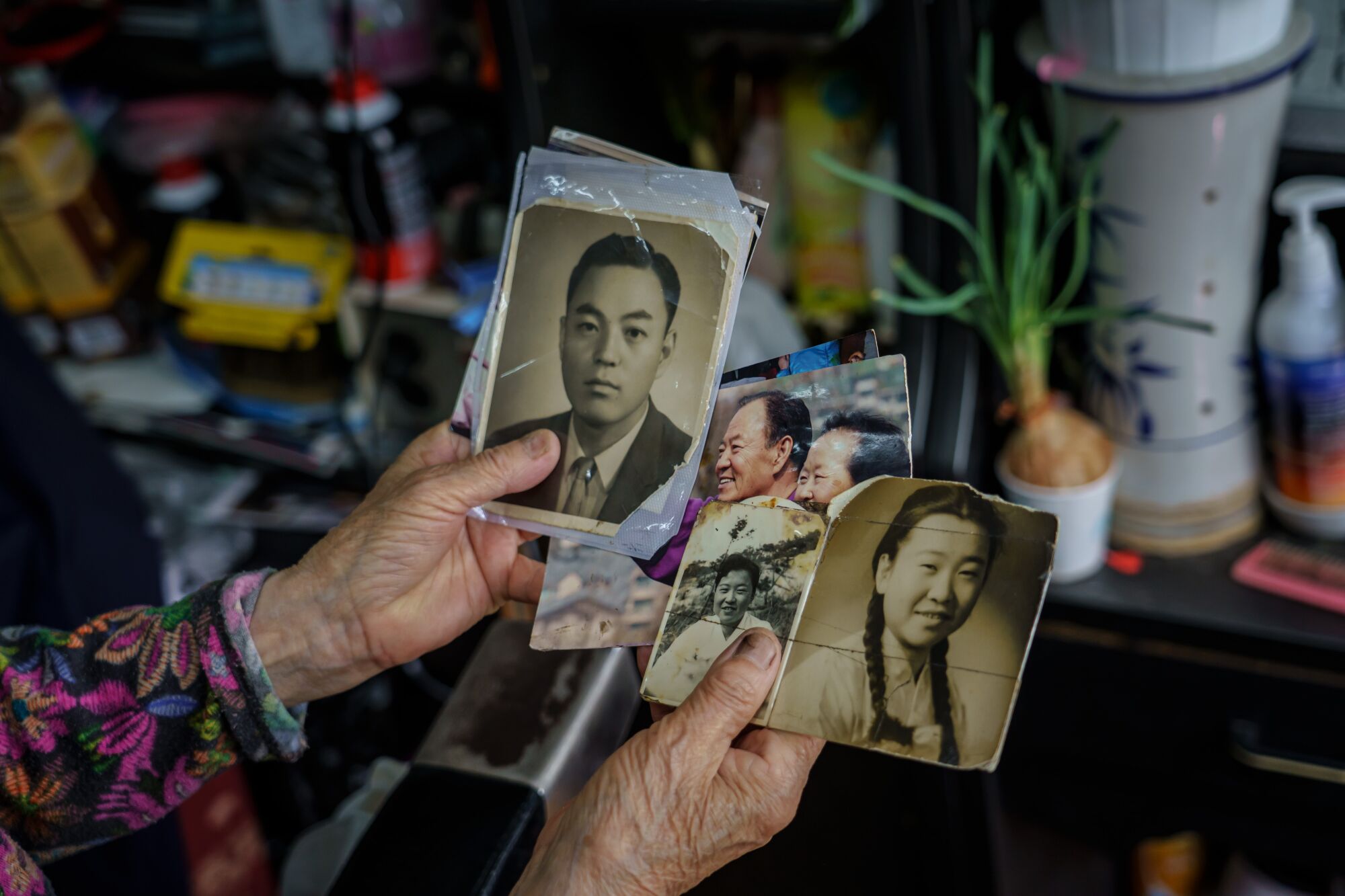 Barber Lee Duk-hoon shows old family photographs at her shop in Seoul