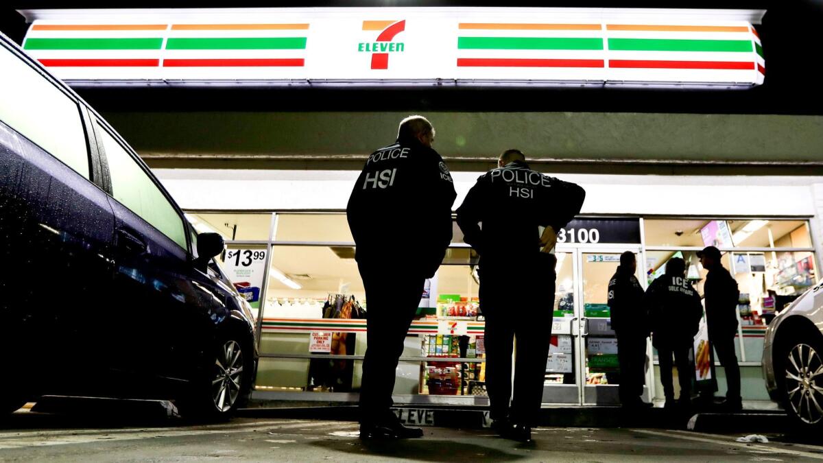 U.S. Immigration and Customs Enforcement agents serve an employment audit notice at a 7-Eleven convenience store in Los Angeles on Jan. 10.