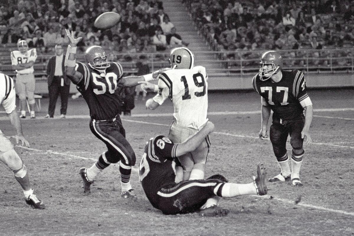 San Jose State's quarterback is harassed by Carl Weathers (50) and Fred Dryer (77). 