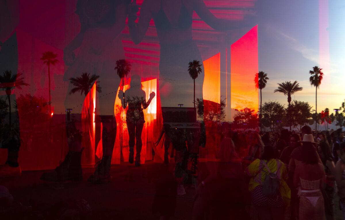 Festival goers walk through Spectra, a seven-story immersive installation as the sun sets on day two at the Coachella Valley Music and Arts Festival. (Brian van der Brug / Los Angeles Times)