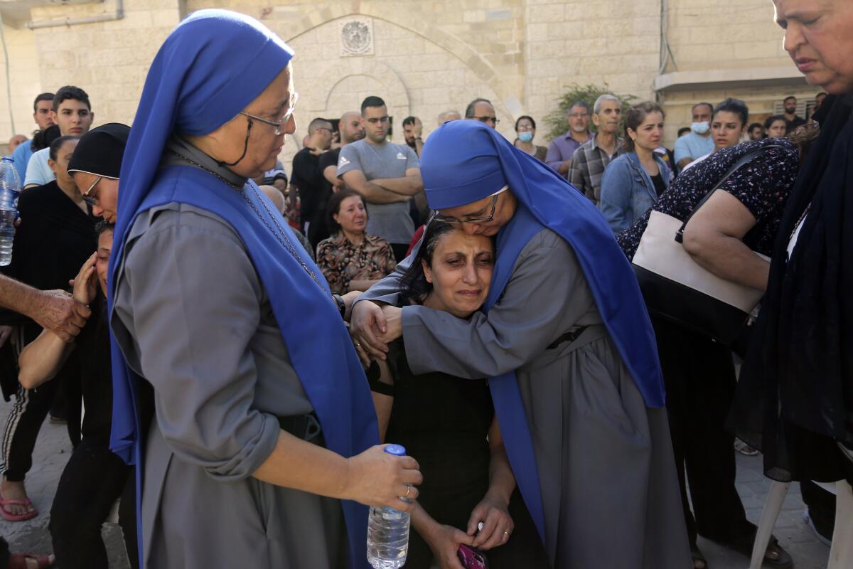 Nuns comfort a Palestinian woman in Gaza City on Oct. 20.