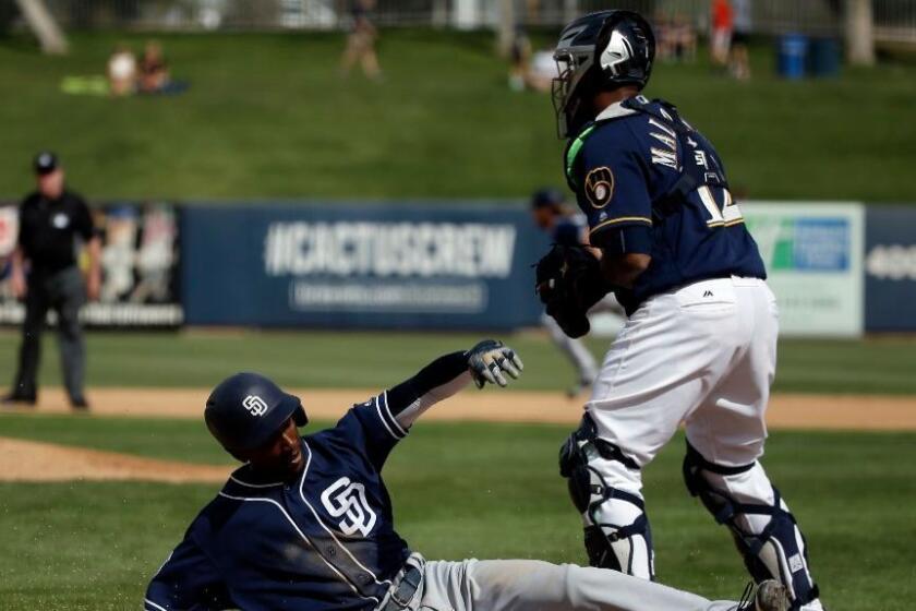 Brewers catcher Martin Maldonado looks on as the Padres' Jemile Weeks scores during the fourth inning of a spring training game on March 7.