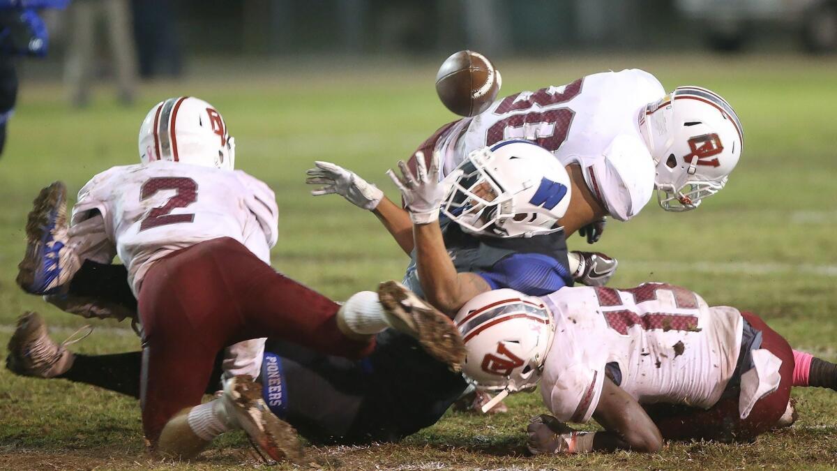 Ocean View High defensive backs Will Earthman (2) and Raelen Bruce (13) force Western's James Mendoza to fumble during a Pac 4 League game on Thursday.