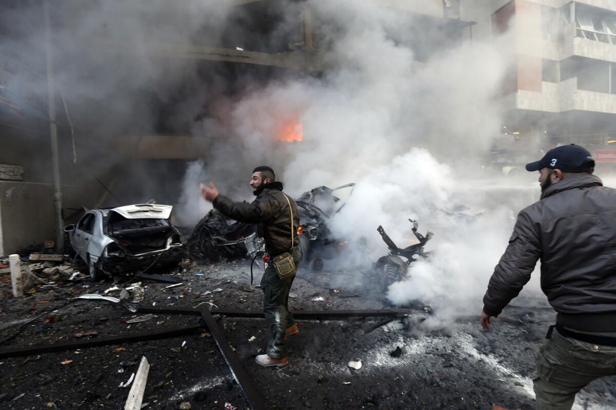 Lebanese people gather Thursday at the site of a bombing in a southern suburb of Beirut.