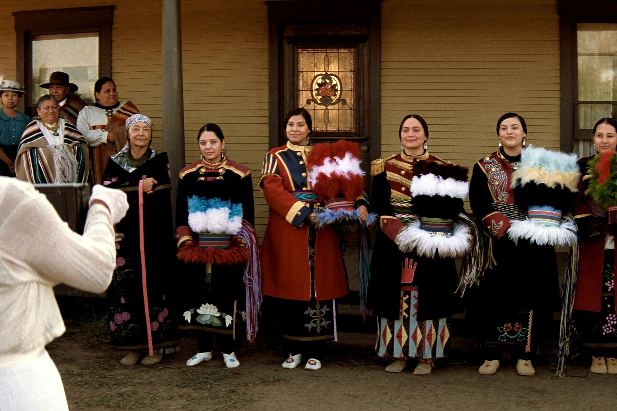 A line of women in adorned military coats stand for a photo in a scene from "Killers of the Flower Moon."