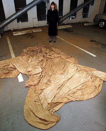 FBI Special Agent Robbie Burroughs with a parachute recently discovered partially buried in a familys field in southwest Washington state. It was located almost exactly at the midpoint of a line drawn between the two spots that authorities think D.B. Cooper could have landed.