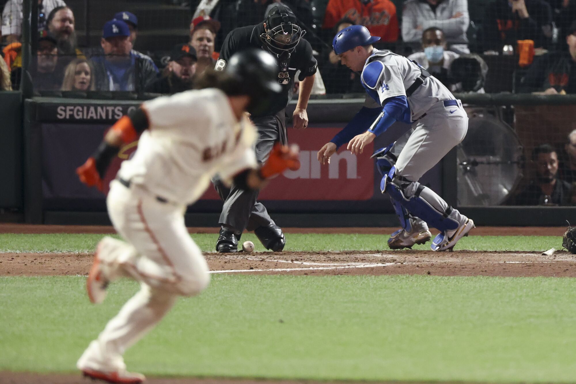 Dodgers catcher Will Smith plays a wild pitch by Julio Urias as Giants' Brandon Crawford heads to second base