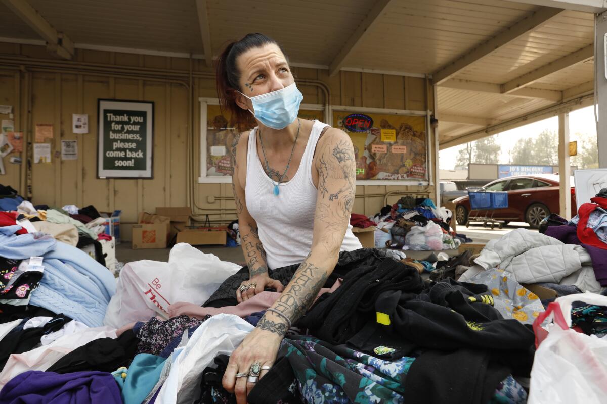 Kristal Buchholz looks through donated clothing after her home was completely destroyed by the North Complex fire